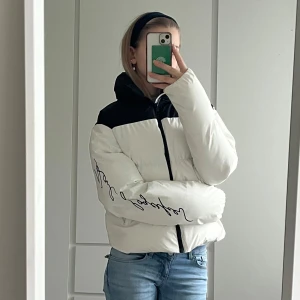 Vit och svart dunjacka från Karl Lagerfeld - Snygg vit och svart dunjacka från Karl Lagerfeld med dragkedja framtill. Skriv till ifall ni behöver fler bilder och vill diskutera priset ❤️