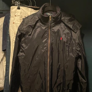 Ralph lauren jacka - En marinblå jacka från Ralph Lauren med dragkedja och huva. Jackan har RL logan på bröstet. Lätt fleece i jackan, perfekt för kyligare dagar. Storlek XL i ungdom storlek, ungefär exakt S. Pris kan diskuteras vid affär.