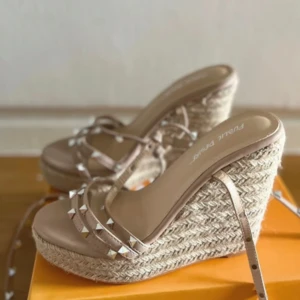 Beige kilklackssandaler med nitar - Snygga beige sandaler med kilklack och dekorativa nitar. Sandalerna har flätad sula och flera remmar som ger en trendig look. Perfekta för sommarens alla tillfällen. Slutsålda på hemsidan!