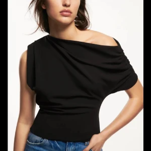 Svart oneshoulder topp - Snygg svart oneshoulder topp med draperad design. Perfekt för en stilren look. Tillverkad i ett mjukt och bekvämt material och endast använd 2 ggr❣️köpt för 2 år sen❣️❣️