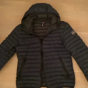 Svart pufferjacka från Colmar - Säljer en stilren mörk blå pufferjacka från Colmar. Skick 9,5/10 inga defekter alls. Strl 46 i herr storlek.  Köparen står för frakt. Nypris:3000kr. Pris kan diskuteras 