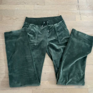 Gröna Juicy Couture  - Snygga gröna Juicy Couture mjukisbyxor i sammet med snörning i midjan och praktiska bakfickor med knappar, strl xs🩷