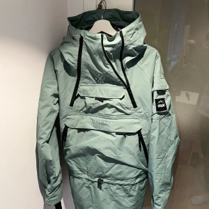 Skidjacka från Dope - Säljer min snowboardjacka från Dope med flera praktiska dragkedjor och en stor huva. Färg: Faded Green. Jackan har en cool design med en ficka på bröstet och en logga på ärmen. Perfekt för skidresan.
