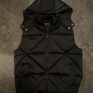 BoohooMan väst - Storlek (S) använd 1 gång. Väldigt snygg svart glansig färg. 