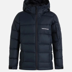 Svart dunjacka från Peak Performance - Säljer en snygg och varm svart dunjacka från Peak Performance. Jackan har en praktisk dragkedja och en skön huva för extra skydd mot kyla. Perfekt för vinterns kalla dagar. Den är i mycket bra skick. Jackan har även ”liftkorts ficka” på armen. Så till er som vill ha ny skidjacka funkar den till det med!! Ny pris 2700kr