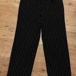 Randiga kostymbyxor  - Randiga svarta kostymbyxor med rak passform från NA-KD. Använda fåtal gånger och i mycket bra skick 
