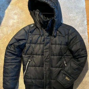 Svart dunjacka från G-Star RAW - Säljer en snygg svart dunjacka från G-Star RAW i storlek S. Den är i  bra skick och har praktiska fickor med dragkedjor. Perfekt för både höst och vinter!