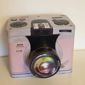 Plåtburk  - Plåtburk från presentbutik i alingsås. Ser ut som en kamera. Linslock går öppna. Två fack. Skramlar lite. Djup. Vacker. Lite svår öppna. Förvaring. 65k. Möts i Gbg. 