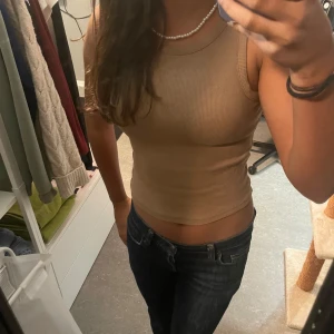 Ljusbrun ribbad linnetopp från Lindex - Säljer en ribbad linnetopp i storlek 134/140. Den är i mycket bra skick och passar till de mesta.