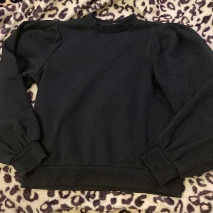 Svart tröja från Vero Moda - Säljer en svart tröja från Vero Moda i storlek S. Den har långa ärmar med puffiga axlar och ribbade muddar. Perfekt för en stilren look i höst och vinter. Tröjan är i bra skick och redo för nya äventyr!