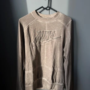 Beige sweatshirt från Nike - Hej, jag säljer nu min as snygga retro Nike revival jersey. Tröjan är fortfarande i väldigt bra skick!! Tröjans storlek är S men oversize! Tröjan är köpt på asos för flera år sedan med ett nypris på 850 kr. Skriv om du har någon fråga😊