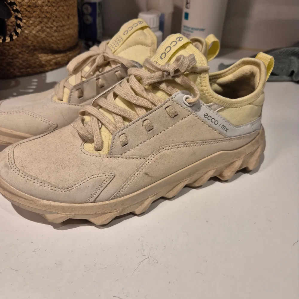 Säljer ett par snygga och bekväma beige sneakers från Ecco. De har en robust sula med bra grepp och snörning för perfekt passform. Perfekta för vardagsbruk eller lättare vandring. Skorna är i jättebra skick då jag använt dessa 1 gång. Passar perfekt för vår och höst!. Skor.