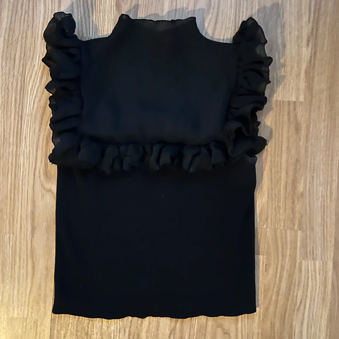 Svart topp med volangdetaljer - 90