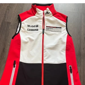 Adidas Porsche väst - Säljer en cool Porsche motorsport x Adidas väst i rött, vitt och svart från 2014. Limited edition och säljs inte längre. Storlek S. Dam modell, fitted passform. Aldrig använd och har en sportig look. Skriv för mer info eller bilder! 💕