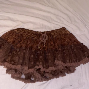 Brun minikjol - En brun minikjol men ”inbyggda” shorts. Köptes på röda korset för 60kr. Oklar storlek men den är väldigt stretchig och passar mig bra som oftast har M-L