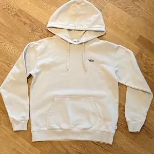 Säljer en snygg beige hoodie från Vans i mycket bra skick. Den har en stor ficka fram och ett coolt blommigt mönster med Vans-logga på ryggen. Perfekt för höst och vår! 🧢