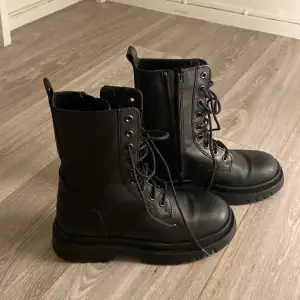 Säljer ett par svarta boots från Zara i mycket bra skick. De har både snörning och dragkedja för enkel på- och avtagning. Perfekta för höst och vinter med sin robusta sula och stilrena design. Passar till både vardag och fest!