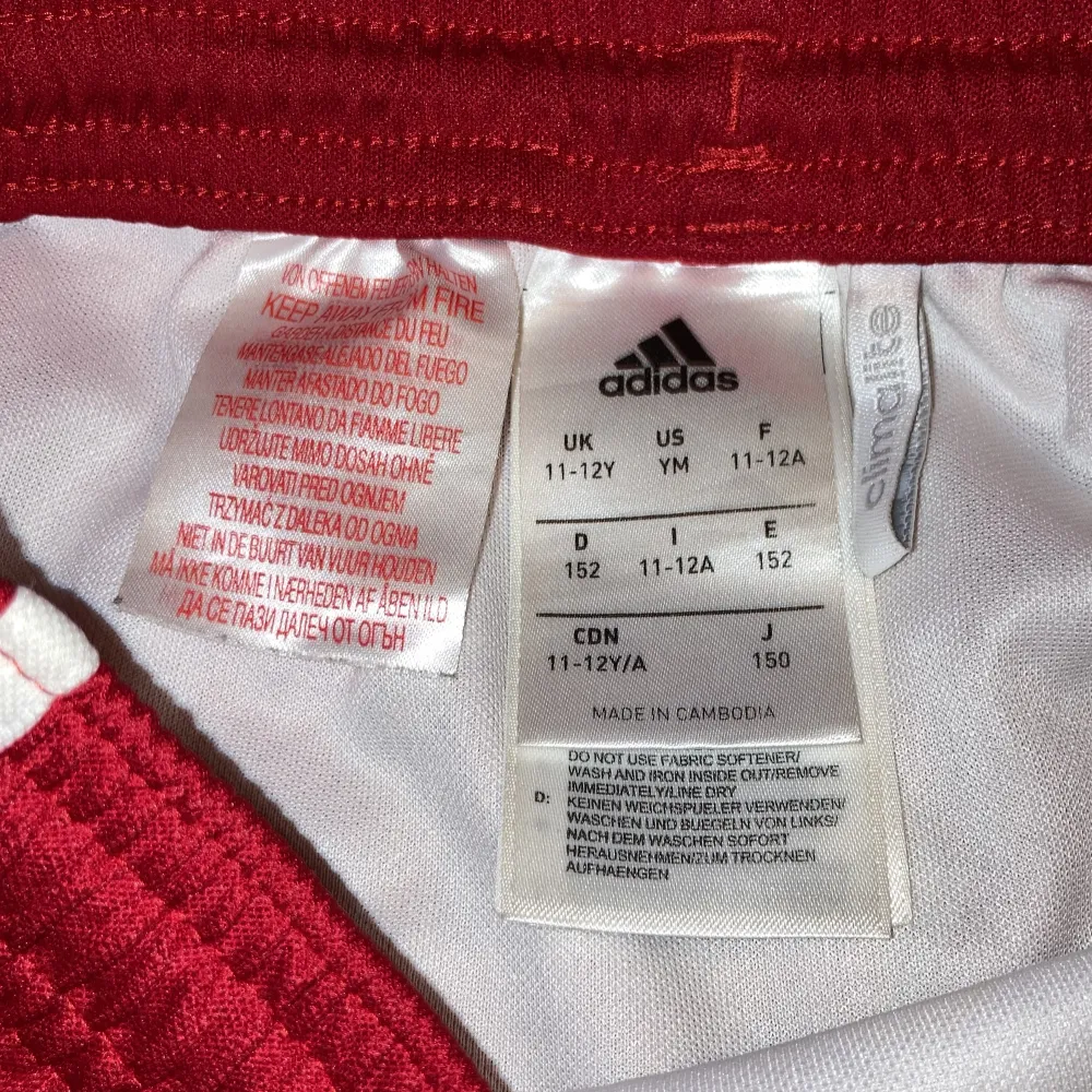 Säljer ett par röda Adidas shorts i mycket bra skick. De har de klassiska tre vita ränderna längs sidorna och är gjorda i ett bekvämt polyester material. Perfekta för träning eller en avslappnad dag. Passar bra till sommarens alla aktiviteter! 🔥. Shorts.