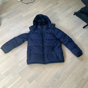 Polo Ralph Lauren  - Polo dunjacka i färgen mörk blå storlek XL (18-20). Skick 9/10 nästan som ny inga skador eller smuts.