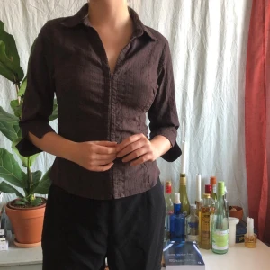 Blus - Mörkbrun skjorta/ blus. Insydd där bak men går att sprätta upp om så önskas. Storlek 40 men sitter som 36/S