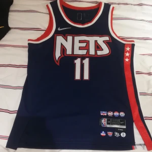 Basketlinne NBA - Brooklyn Nets - Basketlinne med i storlek L med NBA-laget Brooklyn Nets. Kyrie Irving (#11 på ryggen). Linnet är i gott skick och såklart original. Passar bra på mig som är 1,85 och något bredaxlad. 