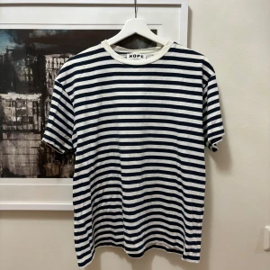 Randig Hope tshirt - Marinblå/vit randig hope tshirt i bra skick. Passar den som bär M/L Nypris tror jag var runt 700-800kr