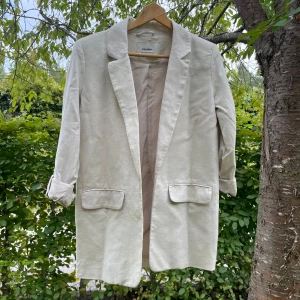 Linnekavaj xs - Linnekavaj i xs. Lite längre modell, beige. Fint skick och sparsamt använd. Från pull&bear.  Ärmar kan kavlas upp se bild! 🥰