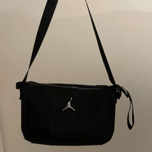 jordan väska - Svart jordan väska köpt från asos. Använd men har inga skador eller fläckar. Bandet är justerbart