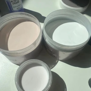 Acrylic Powder och Liquid Set från Aba Group och EM Nail - Säljer ett set med akrylpulver och akrylväska för naglar. Innehåller två burkar akrylpulver från Aba Group i färgerna Cover No.1 och White, perfekt för att skapa snygga nageldesigner. Dessutom ingår en flaska akrylväska från EM Nail för att blanda med pulvret. Perfekt för både nybörjare och proffs som vill ha salongskvalitet hemma!