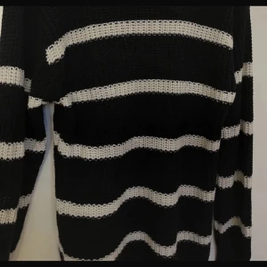 Svart och vit randig stickad tröja - Säljer en supermysig svart och vit randig stickad tröja. Den har långa ärmar och en skön passform som är perfekt för kyligare dagar. Tröjan är i jättebraskick och redo att bli en del av din garderob. Perfekt för både höst och vinter!