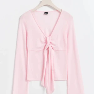 Rosa topp från Gina Tricot - Säljer en superfin rosa topp från Gina Tricot i storlek M. Den har långa ärmar och en snygg knytning framtill som ger en söt look. Perfekt för både vardag och fest! Pris går att diskuteras💕