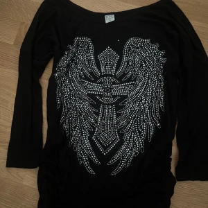 Svart tröja med strassdetaljer från Blind Date - Säljer denna trekvartsärmade tröja från märket Blind Date i storlek S. 