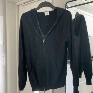 John Henric Kashmir ziphoodie  - Kashmir zip hoodie ifrån John Henric. Nypris runt 2000kr och vårt pris är endast 1049kr. Skick 8,5/10, finns ett hål bredvid taggen, ( bild2). 