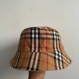 Burberry fiskehatt - Dubbelsidig 2 in one går att vika in den så man har två olika hattar i en. Toppenskick knappt använd 