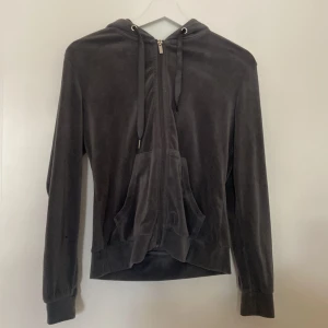 Mörkgrå hoodie från Gina Tricot - Säljer en supermjuk och bekväm mörkgrå hoodie i velour från Gina Tricot i storlek XS. Den har en dragkedja framtill och en praktisk huva med snören. Perfekt för mysiga höstkvällar eller som ett lager under jackan. Den är i bra skick och redo för en ny ägare!
