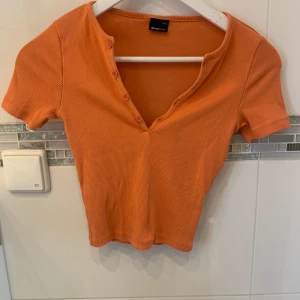 Orange magtröja  - Ganska bra skick använd väldig få, orange magtröja med knappar är i storlek XXS och är från Gina trico 