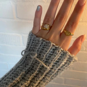 Handledsvärmare - Gråa handeldsvärmare med rosett på. Handledsvärmarna går att vända på om man inte vill ha rosetten så det går att välja själv 🥰