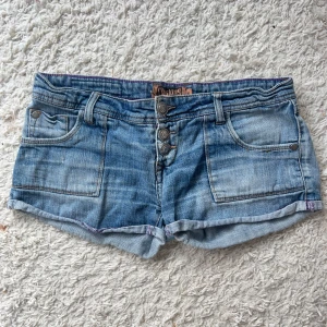 Lågmidjade jeansshorts  - Snygga lågmidjade jeansshorts, storlek 38 enligt lapp. Midjemått:40x2 sträcker sig till ca 43. Har inga bilder på då de är alldeles för stora. Köp sker via köp nu, jag postar inom 24h