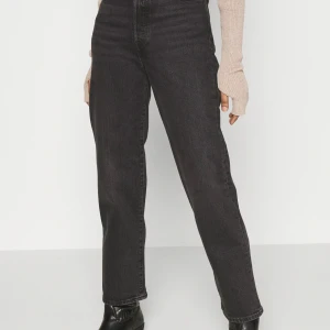 Grå Levi’s jeans - Ett par Levi’s jeans i urtvättad svart tvätt med hög midja och raka ben. Knappt använda pga fel storlek.