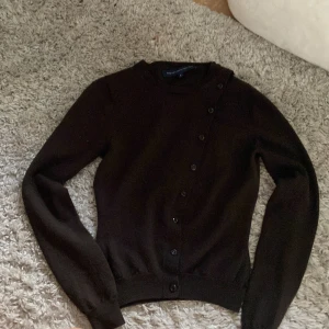 Brun vintage kofta med knapp - Jättesnygg tröja med knappar tvärs över. Mycket bra material och är från French connection. Den har en mer brun färg till den, lappen är även lite lös men är inget så stort problem-man kan sy på den!🤎