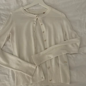 Kofta  - Hej! Säljer en vit kofta med guldiga knappar ifrån Holly and white/ Lindex 🩷