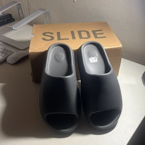 Yeezy slides - Yeezy slides. Använda ett par gånger. Inga repor eller skador. Säljer de för de var för tighta på mig. Har storlek 43 och det har jag men, de passar som 42. Därför vill jag sälja dom.