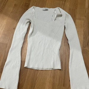 Vit tröja  - Säljer denna vita tröja som är ganska öppen runt brösten. Tröjan är i bra skick och är i storlek M.  Ärmarna på tröjan är lite utsvänga.💕