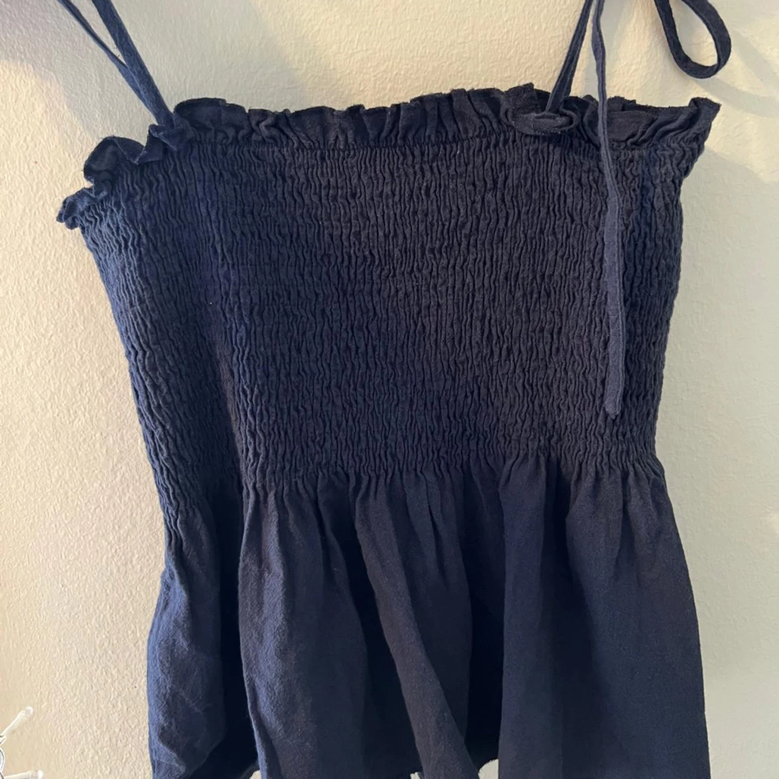 Svart ärmlös topp med volangdetaljer