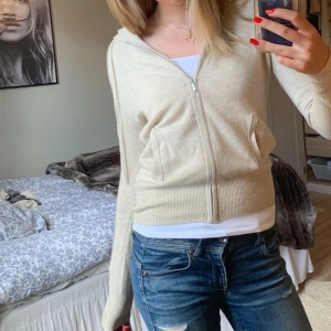 SOFT GOAT CASHMIR - Säljer en supermysig beige stickad hoodie med dragkedja framtill. Den har långa ärmar och en ribbad kant vid ärmslut och nederkant. Perfekt för höst och vår när det är lite kyligt ute. Passar till både jeans och leggings!