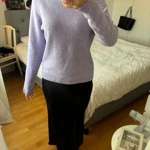 Ljuslila stickad tröja från Vero Moda - Säljer en superfin ljuslila stickad tröja från Vero Moda. Den är perfekt för både höst och vinter med sin mysiga och varma känsla. Tröjan har långa ärmar och en normal passform, vilket gör den både bekväm och stilren. Perfekt att matcha med jeans eller kjol för en avslappnad look!