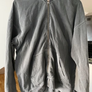 Grå Zip up Hoodie - Säljer denna gråa Zip hoodie från Ronning. Som var en av hans tidigare kollektioner. Är använd men i bra skick. Sitter som storlek medium.