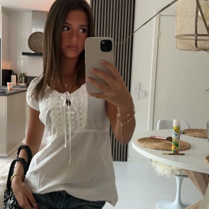 Vit topp - En jättesöt vit topp med söta detaljer och en rosett vid halsen