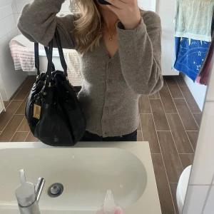 Svart skinnväska med detaljer - Säljer en snygg svart väska från Marc by Marc Jacobs väska med coola detaljer i guld. Väskan är i jättebra skick. Perfekt för både vardag och fest! 🖤