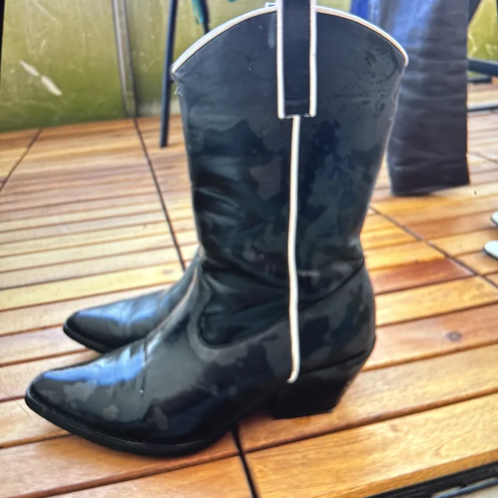 Svarta cowboyboots med vita detaljer som tyvärr inte kommer till användning längre :/. Skor.